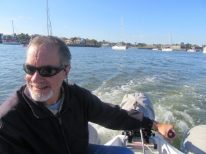 Dudley at the helm of the dinghy, with the outboard engine that I'm trying to conquer.